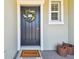 Welcoming front entrance featuring a decorative wreath, neutral tones, and classic brick walkway at 8953 Gallantree Pl, Land O Lakes, FL 34637