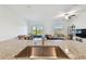 Kitchen island with stainless steel sink overlooks dining and living areas with natural light at 8953 Gallantree Pl, Land O Lakes, FL 34637
