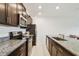 Modern kitchen with stainless steel appliances, granite countertops, and dark wood cabinets at 8953 Gallantree Pl, Land O Lakes, FL 34637