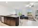 Open-concept kitchen and living area with granite countertops, stainless steel appliances, and tile floors at 8953 Gallantree Pl, Land O Lakes, FL 34637