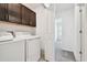 Laundry room with modern washer and dryer and storage cabinets above at 8953 Gallantree Pl, Land O Lakes, FL 34637