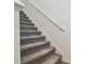 Carpeted staircase with white walls and a white handrail at 8953 Gallantree Pl, Land O Lakes, FL 34637