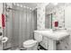 Well-lit bathroom featuring pedestal sink, toilet, and shower with patterned wallpaper at 101 Dogwood Cir, Seminole, FL 33777