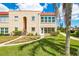 Charming condo featuring two stories, red roof, lush green lawn, and mature palm trees at 101 Dogwood Cir, Seminole, FL 33777