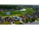 Aerial view of a home on a golf course with a lake and mature trees in a neighborhood at 10103 Old Tampa Bay Dr, San Antonio, FL 33576