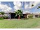 Spacious backyard with green grass, palm trees, and screened-in porch at 10103 Old Tampa Bay Dr, San Antonio, FL 33576