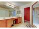 Bathroom with double sinks, wooden cabinets, and a walk-in shower at 10103 Old Tampa Bay Dr, San Antonio, FL 33576