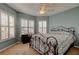 Bedroom with blue walls, carpet, ceiling fan, and windows with white shutters at 10103 Old Tampa Bay Dr, San Antonio, FL 33576