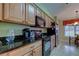Bright kitchen featuring wooden cabinets, black countertops, and stainless steel appliances at 10103 Old Tampa Bay Dr, San Antonio, FL 33576