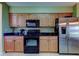 Cozy kitchen featuring wooden cabinets, black appliances, and a stainless steel refrigerator at 10103 Old Tampa Bay Dr, San Antonio, FL 33576