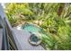 Aerial view of backyard showcasing pool, hot tub, and lush tropical landscaping creating a private oasis at 1058 Roundstone Pl, Palm Harbor, FL 34683