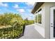 A spacious balcony featuring tile floors, a black metal railing, and scenic views of the lush, tree-filled landscape at 1058 Roundstone Pl, Palm Harbor, FL 34683