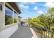 A spacious balcony featuring tile floors, a black metal railing, and scenic views of the lush, tree-filled landscape at 1058 Roundstone Pl, Palm Harbor, FL 34683