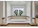 Elegant bathroom featuring a soaking tub with white columns and large windows showcasing decorative design at 1058 Roundstone Pl, Palm Harbor, FL 34683