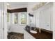 Bathroom with granite countertop, white cabinets, and a window overlooking the yard at 1058 Roundstone Pl, Palm Harbor, FL 34683