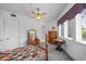 Bright bedroom showcasing a bed, ceiling fan, vintage furniture, and natural light from the window at 1058 Roundstone Pl, Palm Harbor, FL 34683