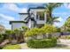 Modern home exterior featuring a spiral staircase, multiple balconies, and lush landscaping at 1058 Roundstone Pl, Palm Harbor, FL 34683