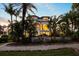 Stately home with large windows and balconies surrounded by lush tropical landscaping and a stone walkway at 1058 Roundstone Pl, Palm Harbor, FL 34683