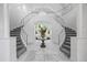 Spacious foyer featuring dual staircases, a decorative table with flower arrangement and bright marble flooring at 1058 Roundstone Pl, Palm Harbor, FL 34683