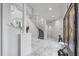 Open foyer with marble floors, a curved staircase, and a decorative statue near the wood-framed front door at 1058 Roundstone Pl, Palm Harbor, FL 34683
