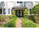 Welcoming front entrance features a beautiful glass front door framed by manicured hedges and trees at 1058 Roundstone Pl, Palm Harbor, FL 34683