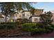 Inviting front yard with mature trees, shrubs, and a brick path leading to the front door at 1058 Roundstone Pl, Palm Harbor, FL 34683