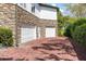 Spacious two-car garage with brick driveway and attractive stone detailing on home's exterior at 1058 Roundstone Pl, Palm Harbor, FL 34683