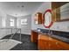 Hallway featuring wet bar with granite counters, custom cabinets and artistic mirror at 1058 Roundstone Pl, Palm Harbor, FL 34683