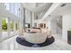 Bright, open living room with unique circular seating, a baby grand piano, and floor-to-ceiling windows at 1058 Roundstone Pl, Palm Harbor, FL 34683