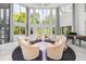 Bright living room with a wall of windows, a circular seating arrangement, and an elegant grand piano at 1058 Roundstone Pl, Palm Harbor, FL 34683