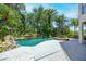 Backyard boasts a luxurious pool and stone hot tub, surrounded by lush tropical landscaping at 1058 Roundstone Pl, Palm Harbor, FL 34683