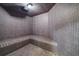 A tiled steam room featuring a corner bench and a ceiling light at 1058 Roundstone Pl, Palm Harbor, FL 34683