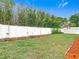 Backyard shot shows the white fence line and the mulch ground cover surrounding the lush green grass at 12083 Rockford St, Spring Hill, FL 34608