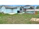 Backyard view featuring the home's light blue siding and a screened pool area with clear blue water at 12083 Rockford St, Spring Hill, FL 34608