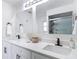Close-up of the renovated bathroom with double vanity with black hardware, quartz counters, and a marble shower at 12083 Rockford St, Spring Hill, FL 34608