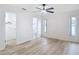 Spacious bedroom with wood-look floors, white walls, two windows, and doorways to the closet and bathroom at 12083 Rockford St, Spring Hill, FL 34608