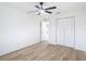 This bedroom features hardwood floors, a ceiling fan, and a closet with white doors at 12083 Rockford St, Spring Hill, FL 34608