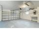 The interior shot of the garage shows the painted floor and walls, a workbench, and a ceiling fan at 12083 Rockford St, Spring Hill, FL 34608