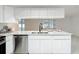 Clean and modern eat-in kitchen featuring white cabinetry, stainless steel appliances, and quartz countertops at 12083 Rockford St, Spring Hill, FL 34608