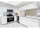 Beautiful modern kitchen with stainless appliances, quartz counters, and white cabinets at 12083 Rockford St, Spring Hill, FL 34608