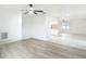 Open-concept living room with wood floors and views to a bright, white kitchen at 12083 Rockford St, Spring Hill, FL 34608