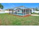 An exterior shot shows the enclosed pool area of the home with lush green grass at 12083 Rockford St, Spring Hill, FL 34608