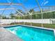 A refreshing screened pool area features a pool with cool blue water and a white fence surround at 12083 Rockford St, Spring Hill, FL 34608