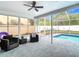 Enclosed patio with comfortable seating beside a screened pool with outdoor lounging areas at 12083 Rockford St, Spring Hill, FL 34608