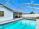 A sparkling pool inside a screen enclosure with a view of the outdoor seating area at 12083 Rockford St, Spring Hill, FL 34608