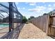 A charming stone path winds beside the screened-in pool toward the fenced backyard at 12215 Adventure Dr, Riverview, FL 33579