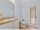 Bathroom offers toilet, vanity with sink, mirror, and private access to the exterior at 12215 Adventure Dr, Riverview, FL 33579