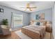 Cozy bedroom with a large window, ceiling fan, and comfortable furniture at 12215 Adventure Dr, Riverview, FL 33579