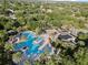 An aerial view of a community pool surrounded by palm trees, sun loungers, and a clubhouse at 12215 Adventure Dr, Riverview, FL 33579