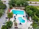 Aerial view of a community pool with lounge chairs, umbrellas, and lush landscaping at 129 Lakeview Way, Oldsmar, FL 34677